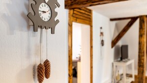 Un reloj de pared con un diseño único de engranajes y adornos de piñas.
