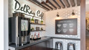 A modern coffee bar with a Starbucks refrigerator, a menu board, and two stools. - Kasa Cozy Studio Amenity Access Alexandria (Alexandria)