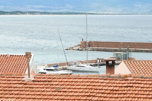 Enjoy breathtaking views of the sea from this coastal retreat, with a sailboat docked at the pier.