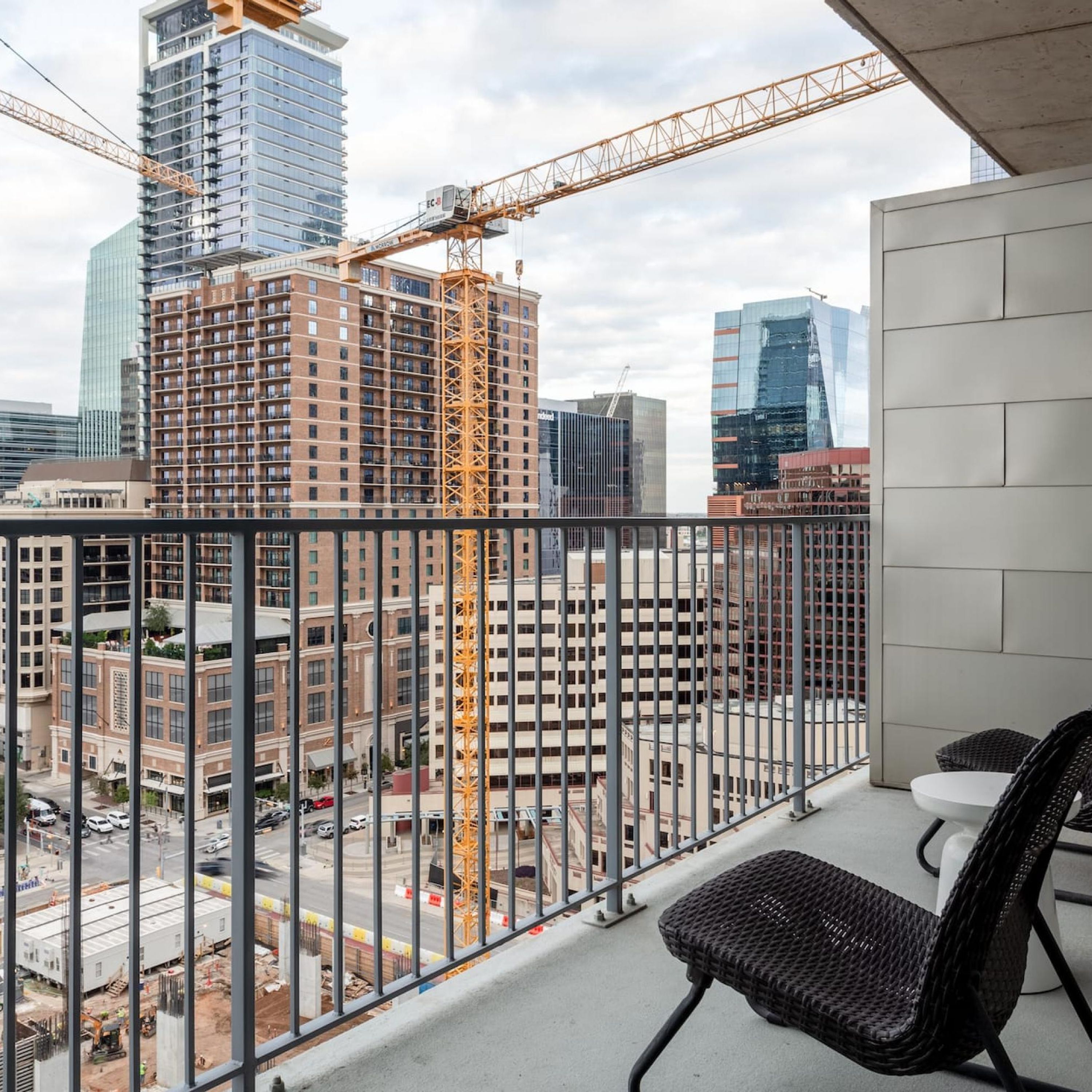 Ein Balkon mit Blick auf eine Baustelle und umliegende Gebäude.