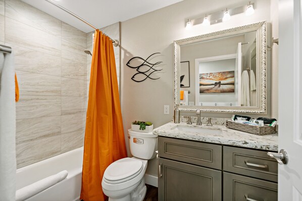 Un bagno con vasca, servizi igienici e lavabo con specchio.