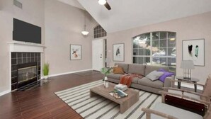 A spacious living room with a fireplace, a large sofa, a coffee table, and a ceiling fan. - Enjoy a nice home with a beautiful garden.   (Fort worth)