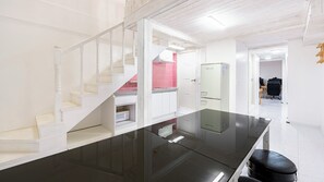 A modern kitchen with white cabinetry, a black countertop, and a stainless steel refrigerator. - Gyeongju Jullietapoolvilla&kidspension (Gyeongju)