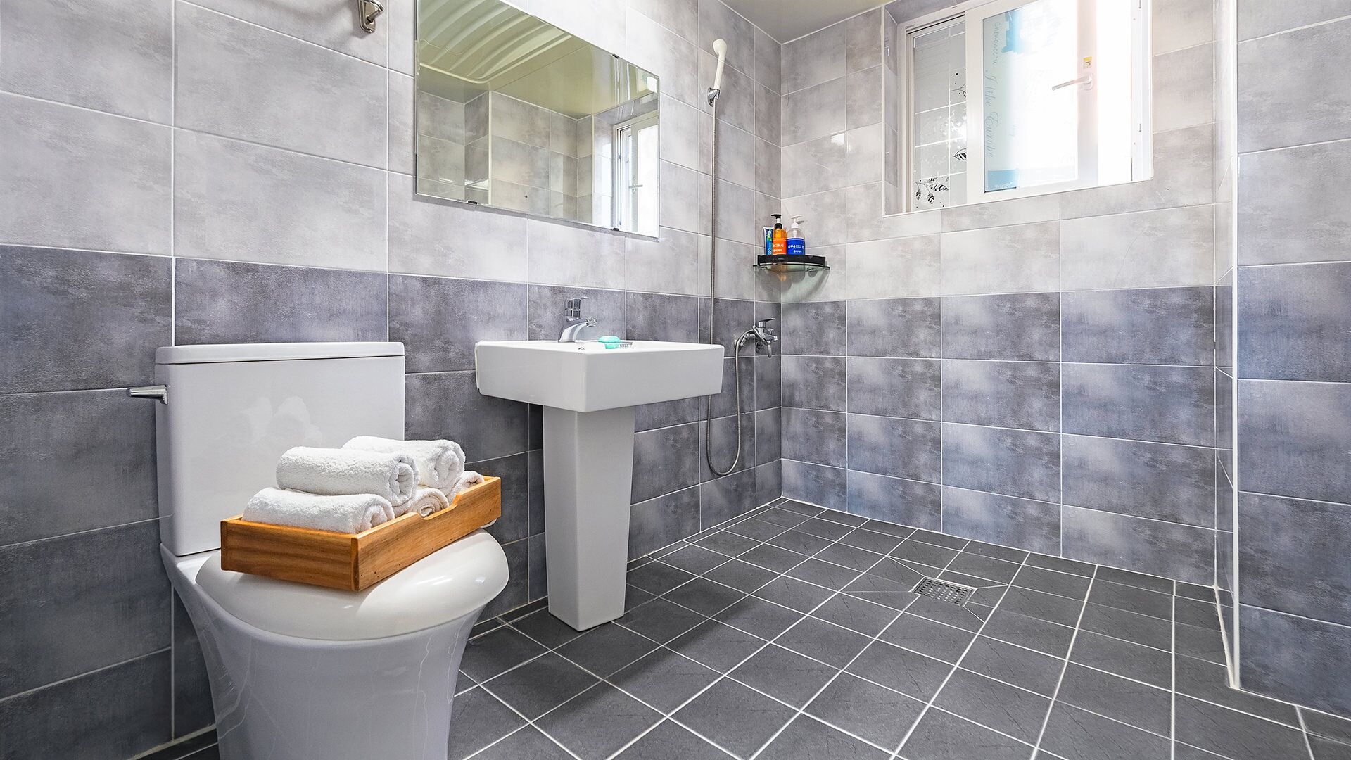A modern bathroom with a toilet, sink, and shower.