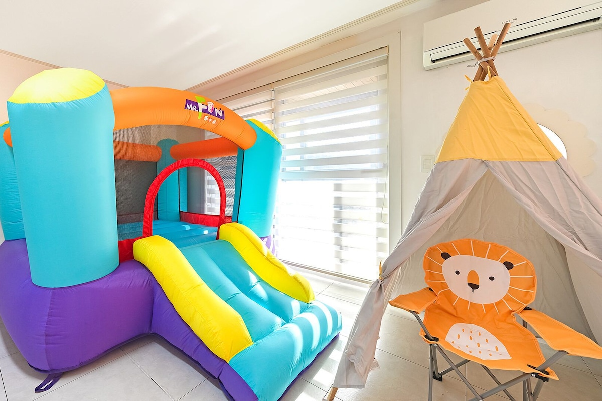 A room with a colorful inflatable play area and a small tent.