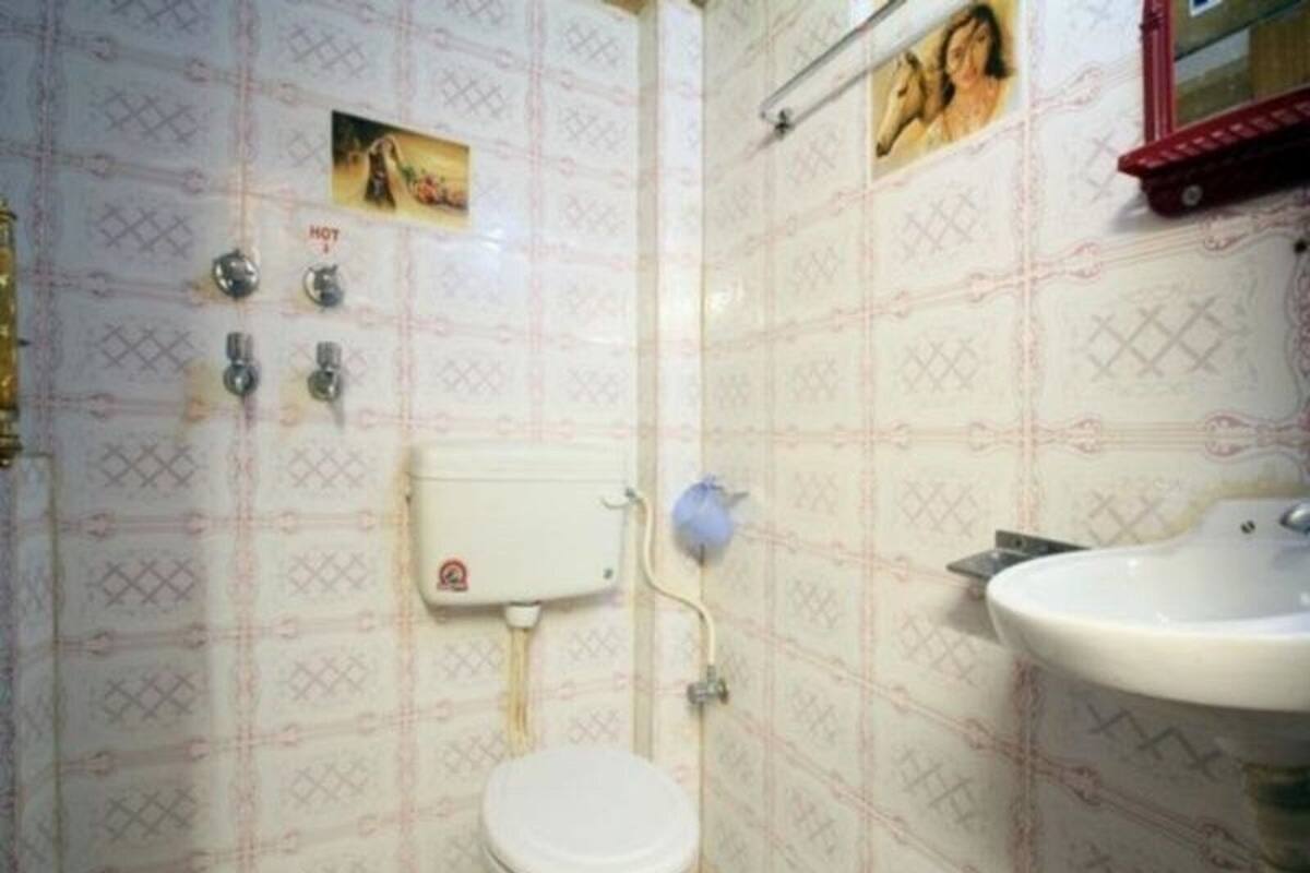 A small bathroom with a toilet, sink, and shower.