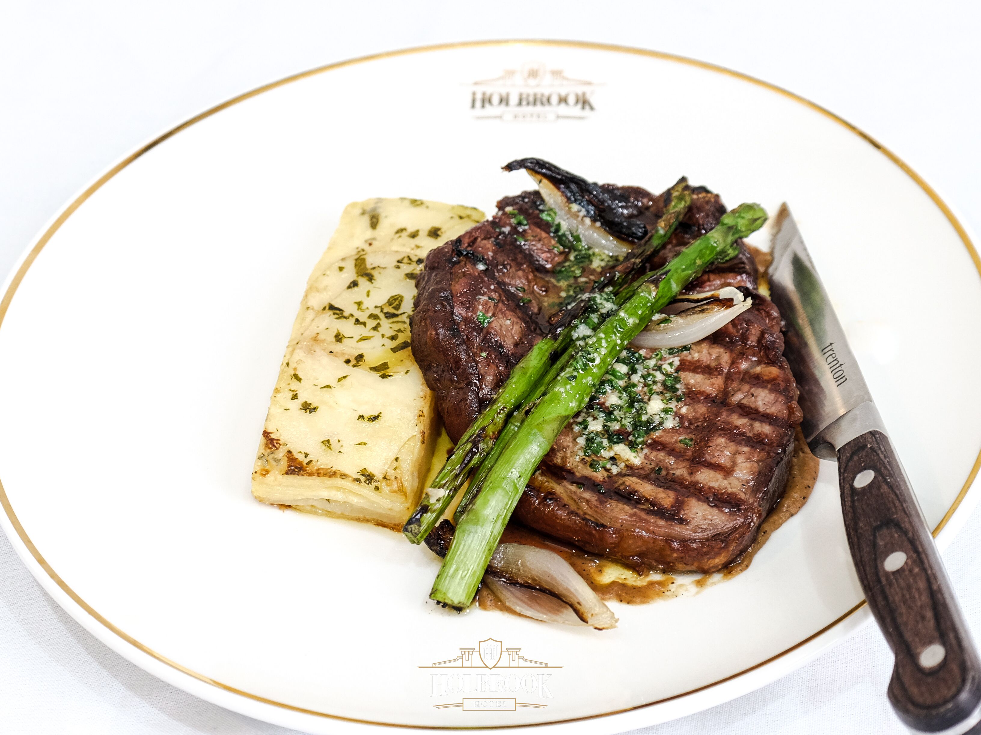 Une assiette contenant un steak, des asperges et une portion de purée de pommes de terre.