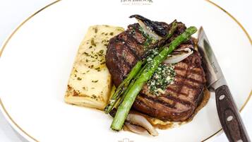 Une assiette contenant un steak, des asperges et une portion de purée de pommes de terre.