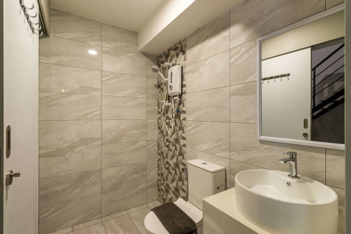 A modern bathroom with a shower, toilet, and sink.
