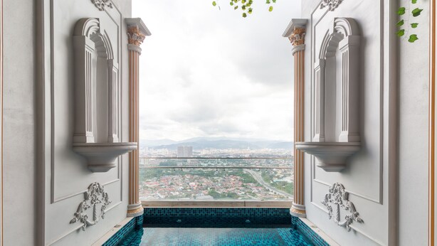 Blick vom Balkon auf einen Pool mit Blick auf eine Stadtlandschaft.