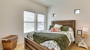 A bedroom with a wooden bed, a nightstand, a lamp, and a window with blinds. - Pool, Game Room! Family-Friendly Surprise Retreat (Surprise)