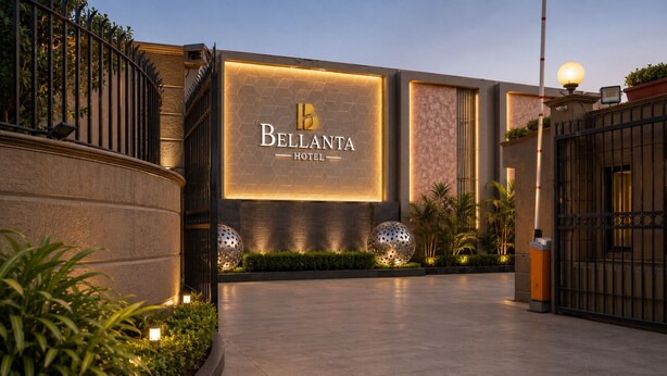 Das äußere Erscheinungsbild des Bellanta Hotels mit einem markanten Eingang, einer gut beleuchteten Fassade und einem Sicherheitstor.