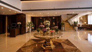 Eine Lobby mit einer Rezeption, einer Treppe und einer Sitzecke.