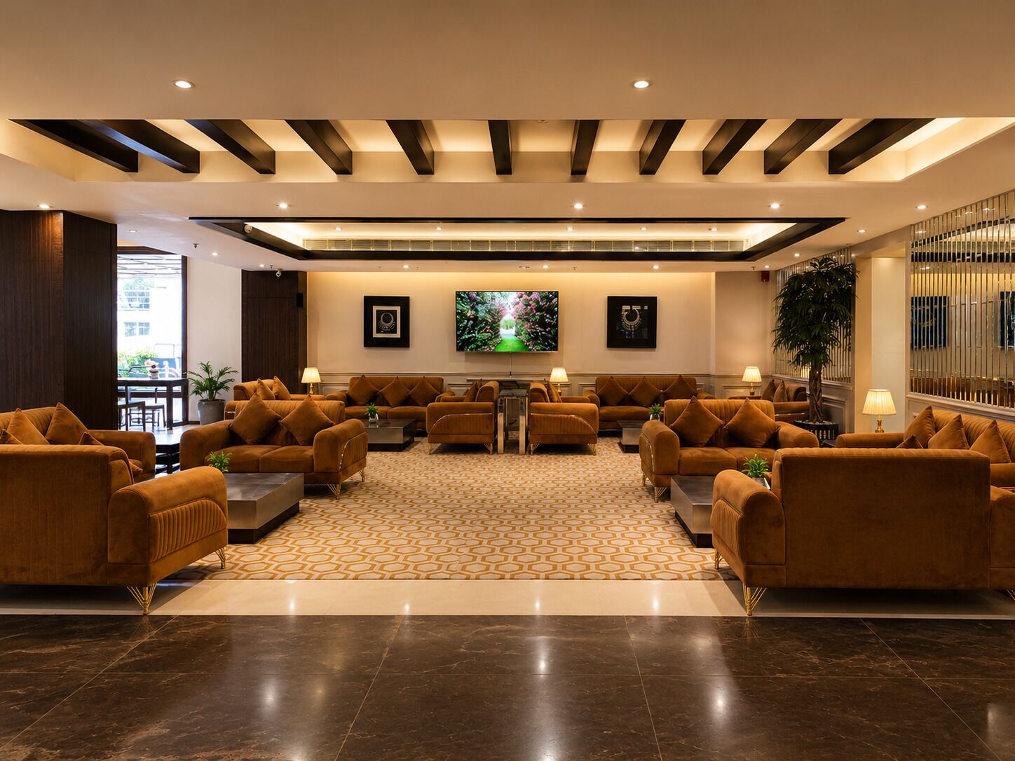 A spacious lobby with multiple sofas, a central coffee table, and a patterned carpet.