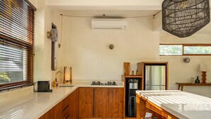 A modern kitchen with wooden cabinets, a built-in stove, and a refrigerator. - Nowhere Villa (Pecatu)