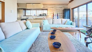 Un salon moderne avec un canapé, une table basse et une décoration sur le thème du surf.