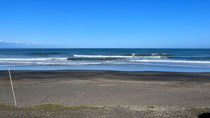 Une plage avec un ciel dégagé et des vagues sur l’océan.