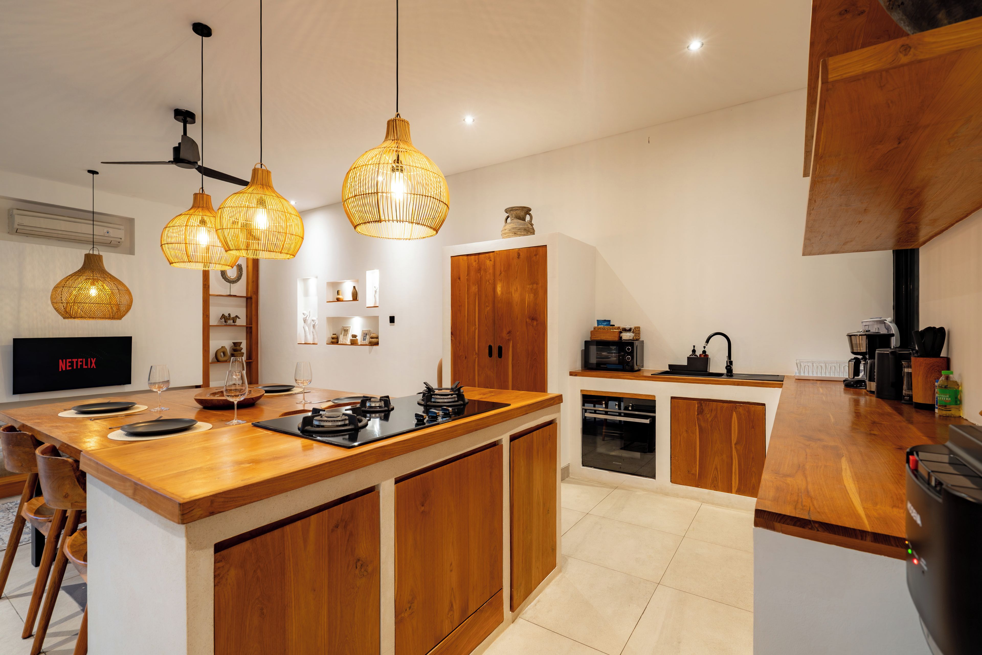 Una cocina moderna con armarios de madera, una isla central e iluminación colgante.