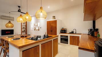 Una cocina moderna con armarios de madera, una isla central e iluminación colgante.