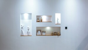 Parede com diversas instala ções artísticas, incluindo esculturas e obras emolduradas.