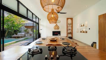 Una cocina moderna con una isla grande, un comedor y vistas a una piscina y jardín.