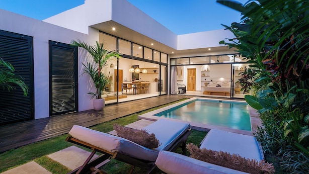Uma casa moderna com piscina, área de estar externa e interior bem iluminado.