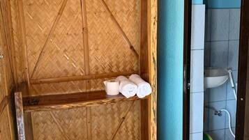 A bathroom with a bamboo wall, a sink, and a toilet.