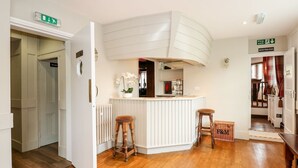 Una cucina moderna con isola bianca, sgabelli di legno e un cartello 'Uscita di sicurezza' ben visibile.