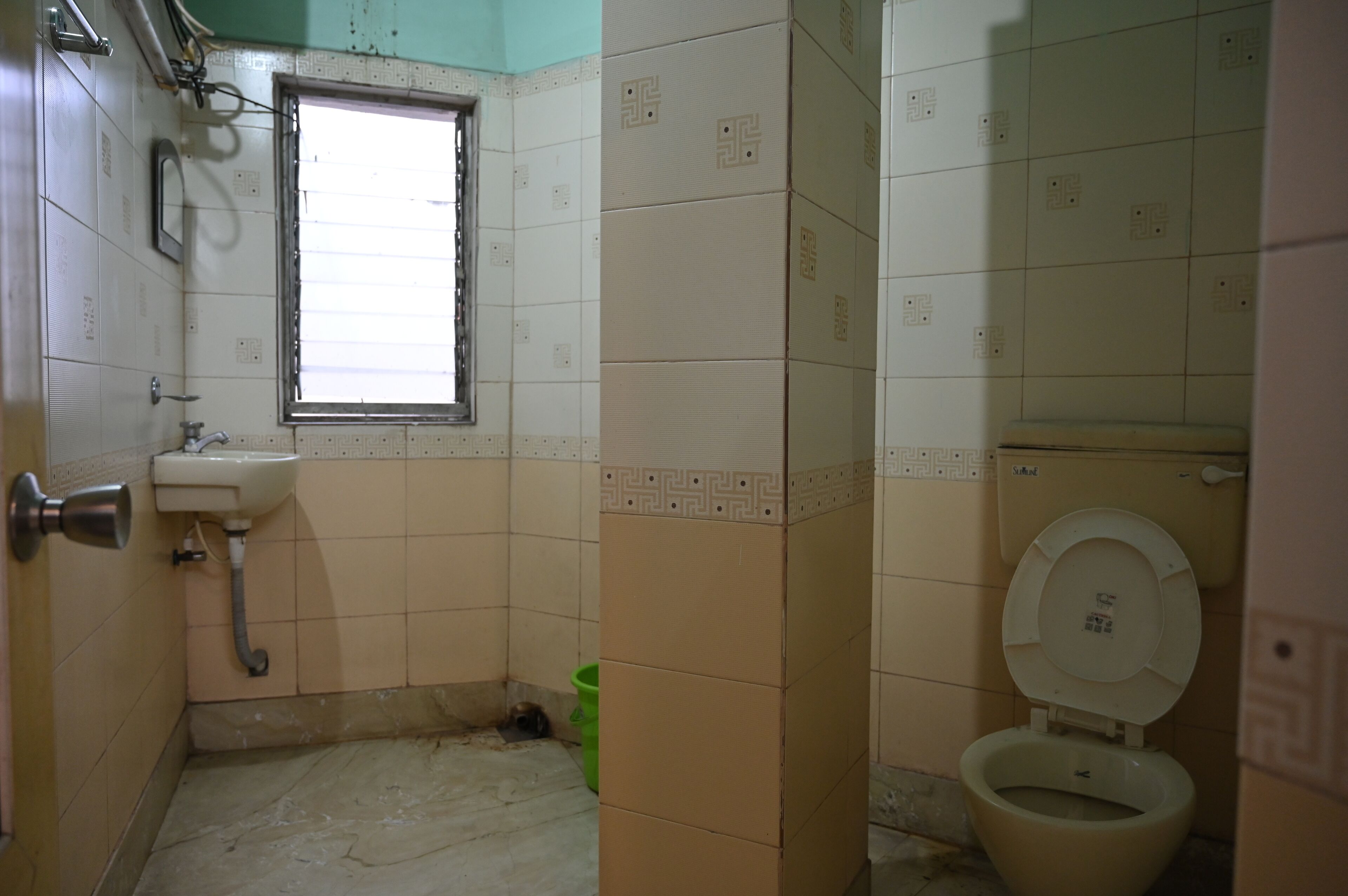 A small bathroom with a window, a sink, and a toilet.