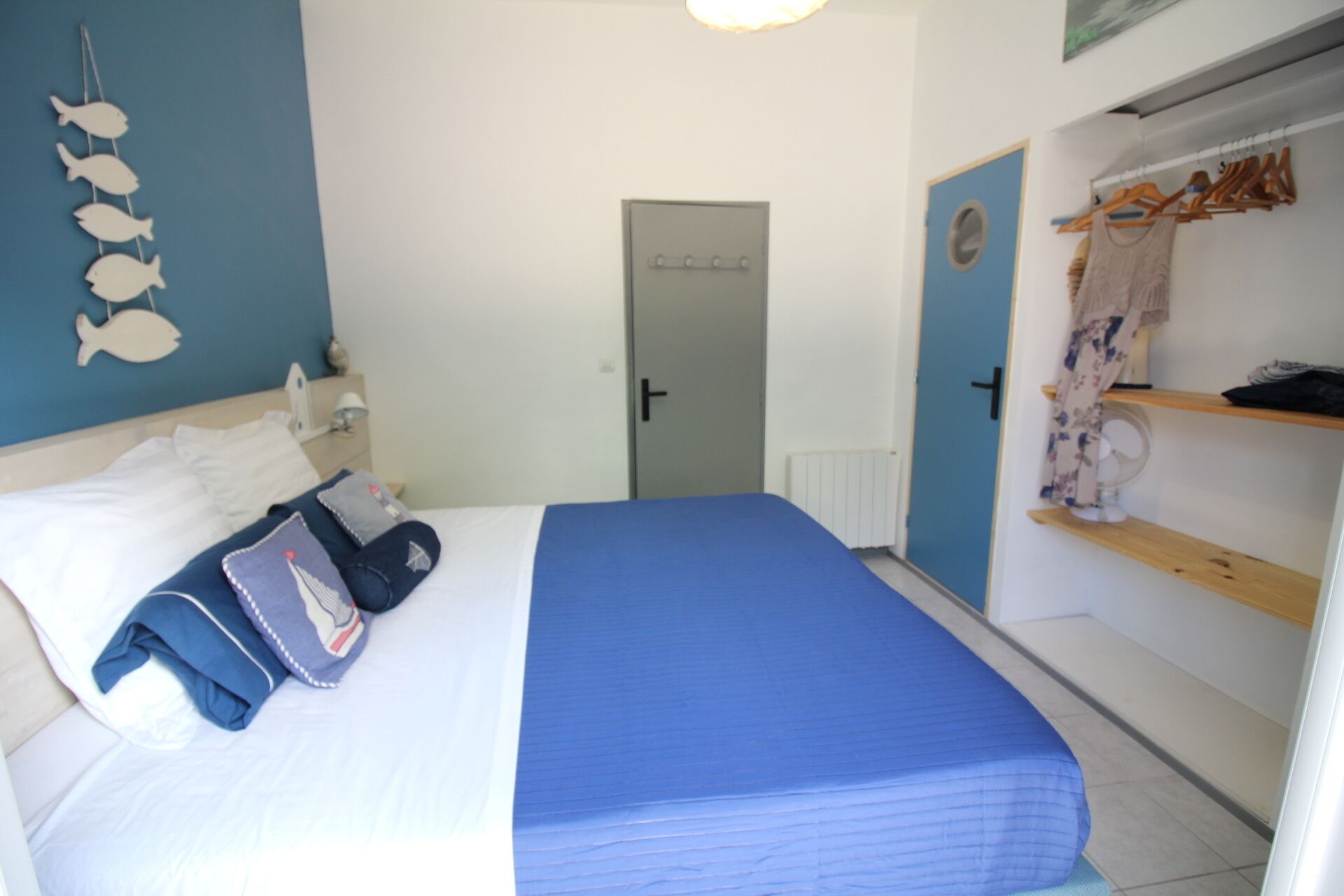 Una camera da letto con un letto, un armadio, una porta e un addobbo a parete.