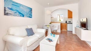 Una sala de estar moderna con un sofá blanco, una mesita de centro y un cuadro en la pared.