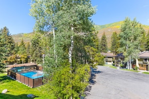 A residential area with a swimming pool, houses, and a mountain backdrop. - West Vail Ptarmigan Townhome - Hot Tub & Easy Bus (Vail)