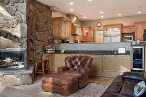 A modern kitchen with stone walls, wooden cabinets, and a built-in oven. - Large East Vail Home - Steps to Bus & Gore Creek (Vail)