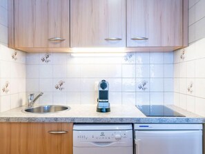 Een koelkast, een magnetron, een vaatwasser, kookgerei, borden en bestek