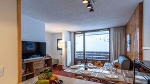 Ein modernes Hotelzimmer mit Essbereich, Fernseher und einem Balkon mit Blick.