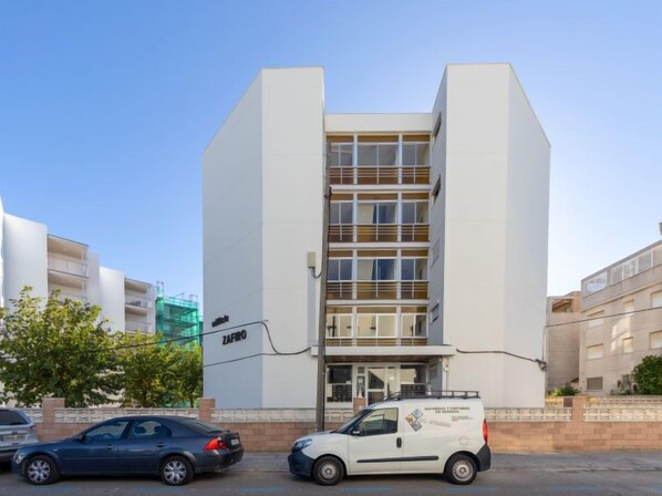 A modern building with a flat facade, large windows, and a sign reading "ZAFIRO".
