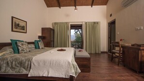 Een slaapkamer met een bed, een bureau en uitzicht op de omgeving.