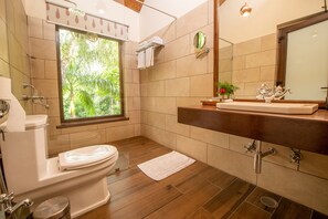 Une salle de bain avec des toilettes, un lavabo et une douche.