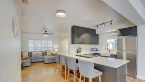 A modern kitchen with a central island, bar stools, and a built-in oven. - Tranquil Poolside Bliss + Pergola Deck & Turf Yard (Fort Lauderdale)