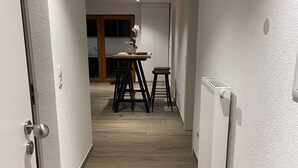 A hallway with wooden flooring, white walls, and a radiator on the right. - Kellerwohnung (Seelbach)