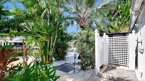 A tropical garden with a pathway leading to a gated entrance. - Wilton on the Water -Courtyard & Heated Pool 4/2.5 (Wilton Manors)