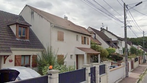 Un carrer residencial amb cases, una tanca amb reixa i pals de serveis.