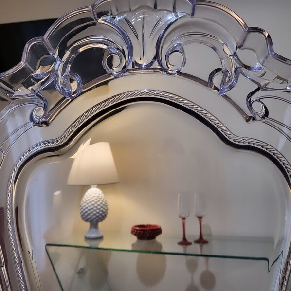 A mirror with an ornate silver frame and a glass shelf below. - Atena apartments 2 Agrigento center (Agrigento)