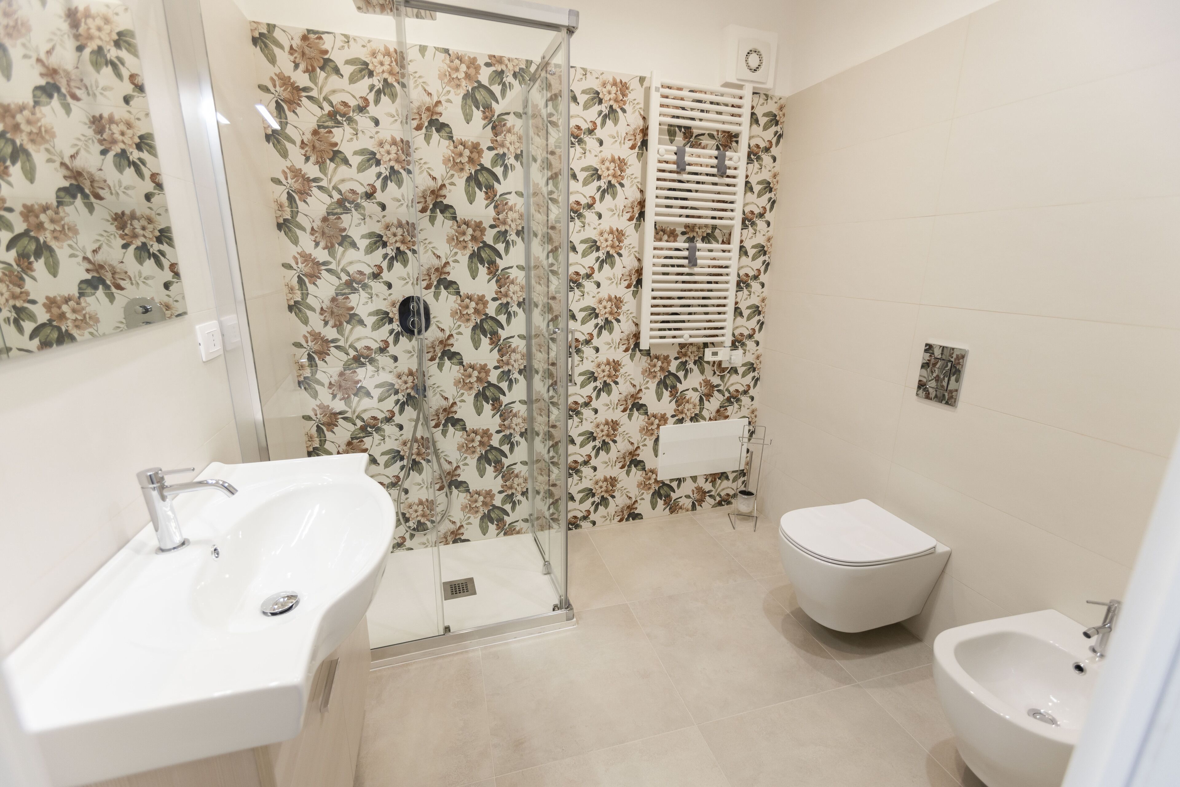 Une salle de bain équipée d’une douche, de toilettes, d’un bidet et d’un lavabo.