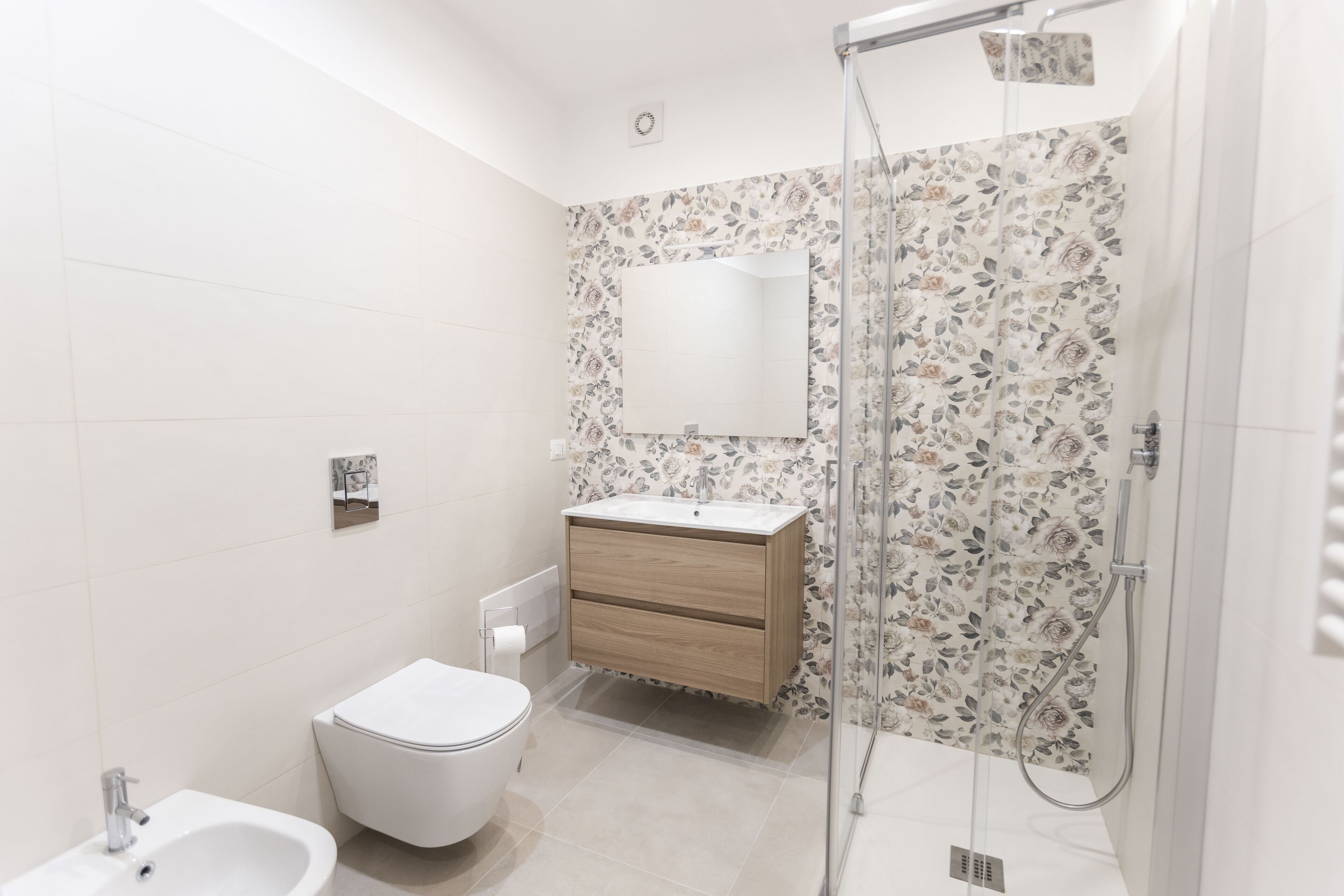 A modern bathroom with a toilet, sink, and shower.