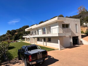 Situated on a well-maintained lawn, this two-story building offers ample natural light and outdoor space through large windows and balconies.
