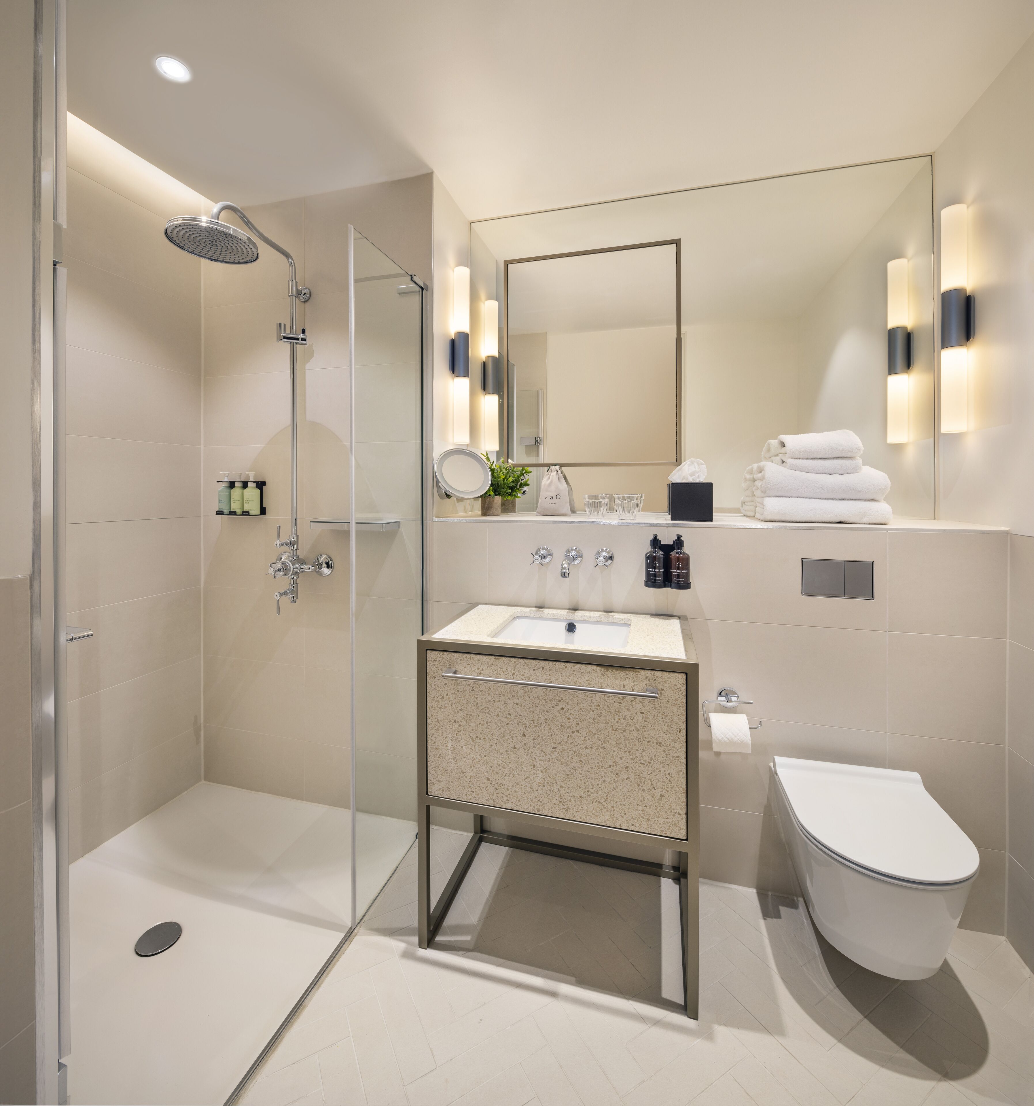 A modern bathroom with a glass-enclosed shower, a freestanding sink with a granite countertop, a large mirror, and a toilet.