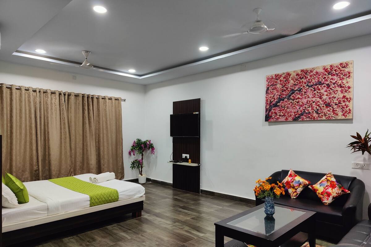 A modern living room with a bed, a sofa, a coffee table, and a painting on the wall.