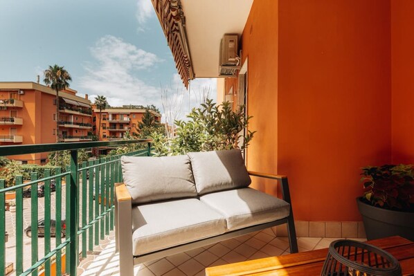 Un balcon avec un canapé, une table et une chaise.