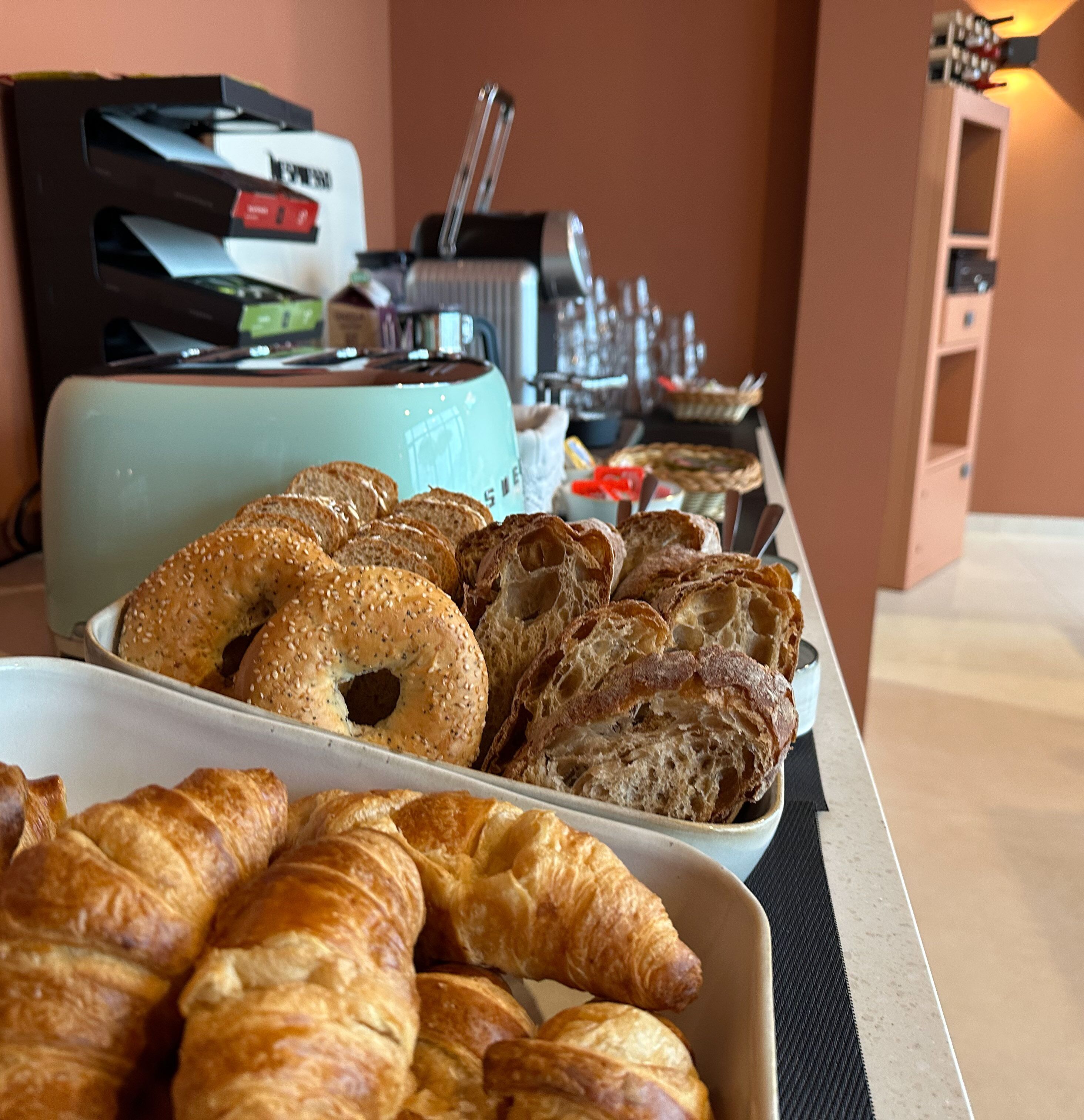 A buffet table with various breads and pastries.